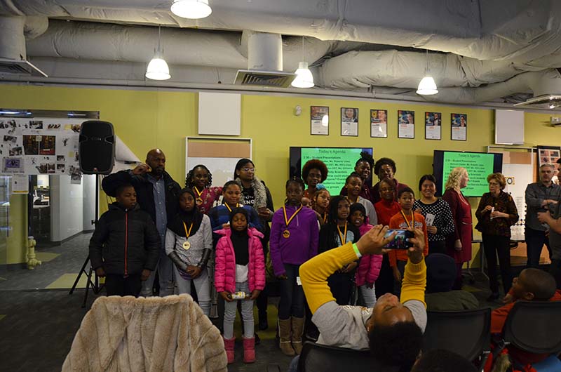 A group of students, teachers and family members pose for pictures at the Dec. 8 event at Drexel's ExCITe Center. 